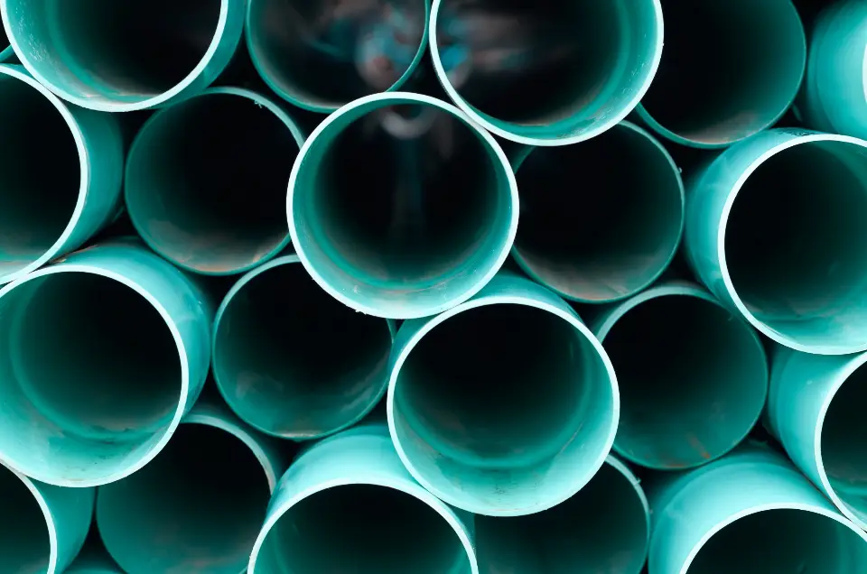 Stack of new plastic drainage pipes seen end-on