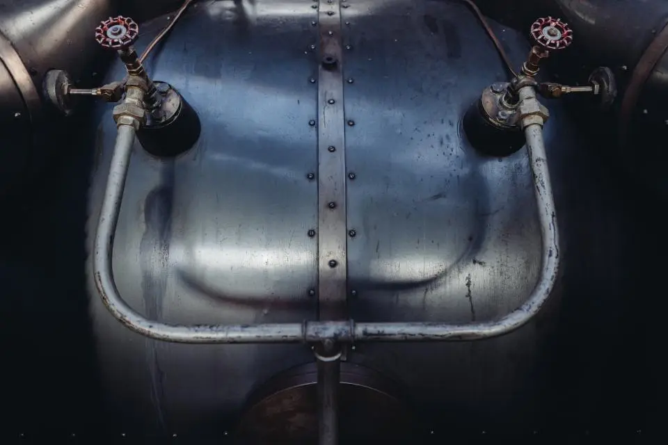 Close-up of metal pipework with red-handled valves